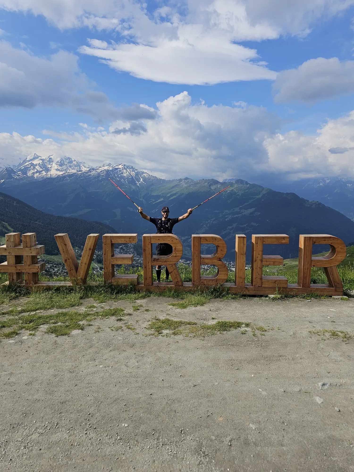 Aurélien Roscini Vitali, ostéopathe du trail, bâtons levés devant le panorama de Verbier sur les sentiers de l'UTMB